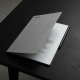 reMarkable Paper Pro Book Folio – Gray reMarkable Paper Pro Book Folio case in gray polymer weave, showing closed front cover with magnetic strap and snap-in tablet mount